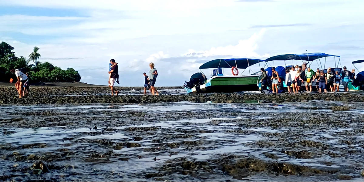 Tourists landing on the rocky beach at Sirena Station during low tide, Corcovado National Park.